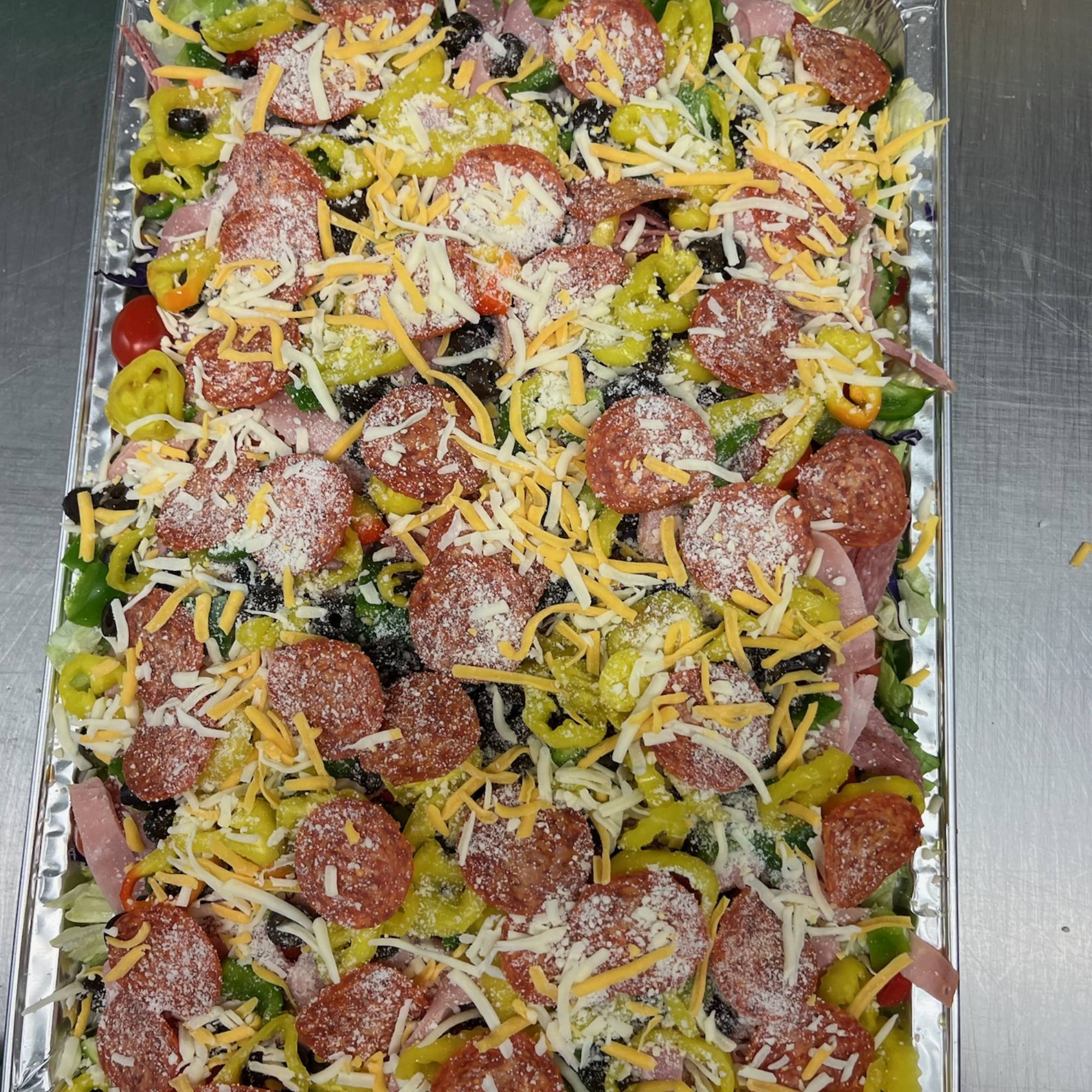 A tray of food with sausage, cheese and other toppings.