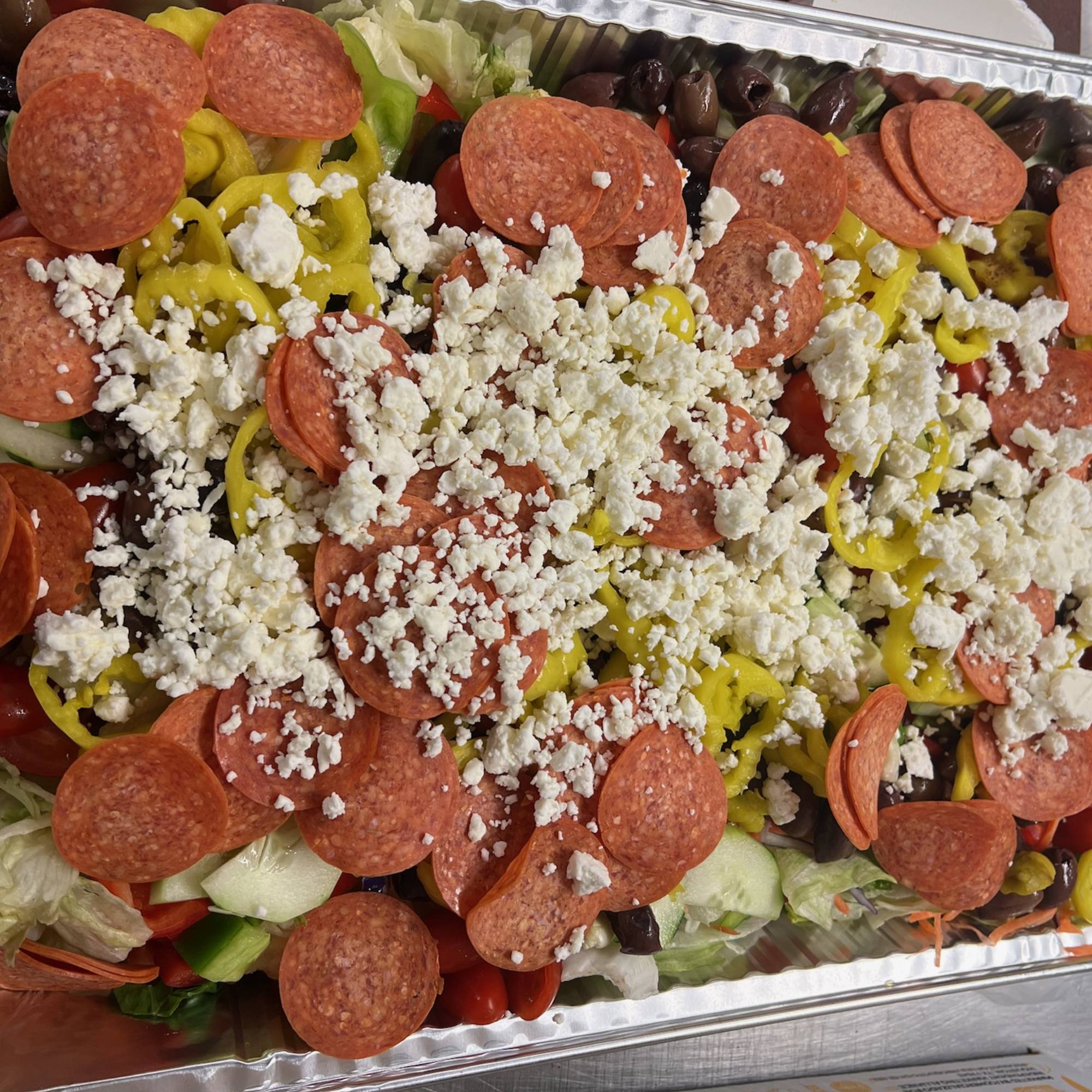 A tray of food with pepperoni, cheese and other toppings.