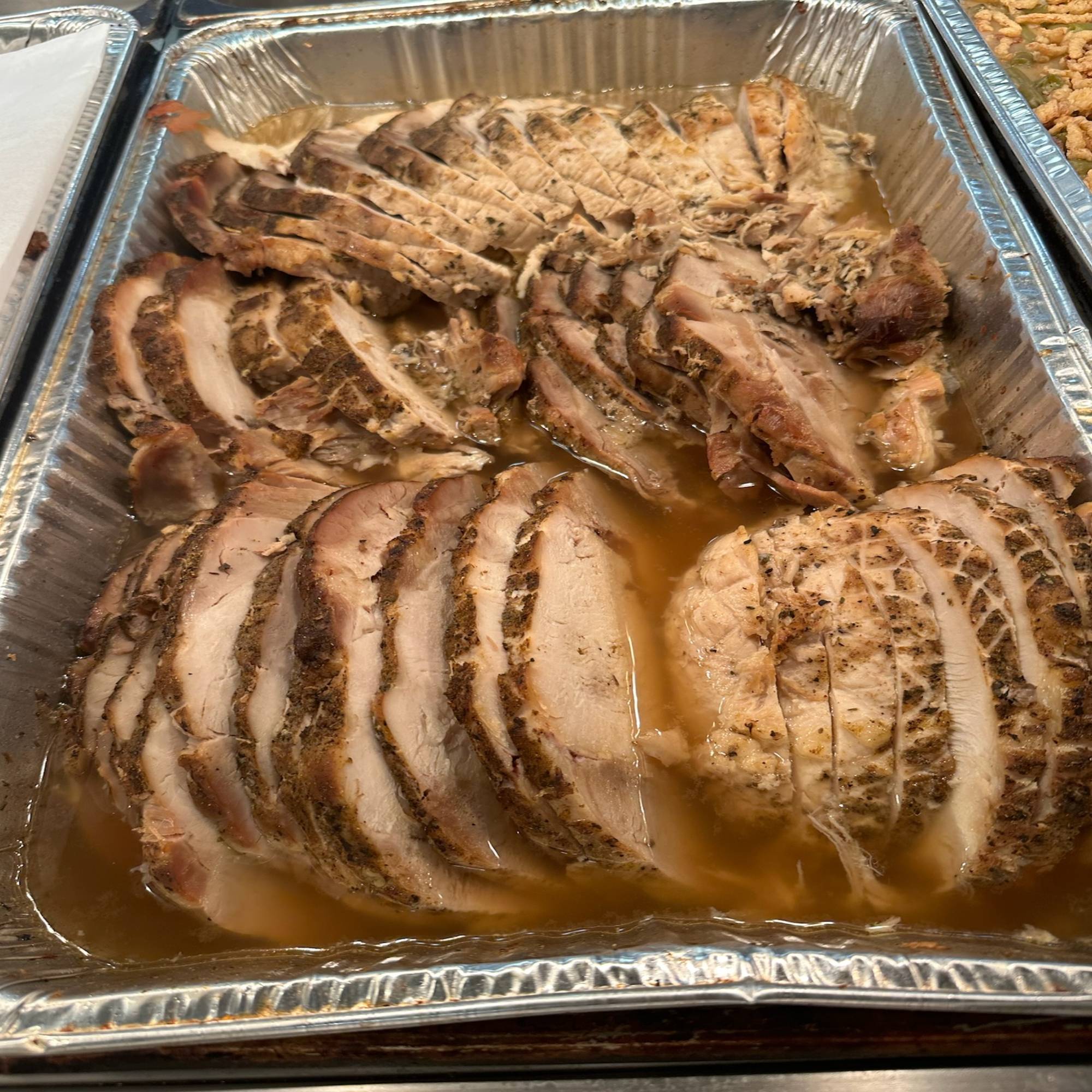 A tray of meat is sitting on the table.