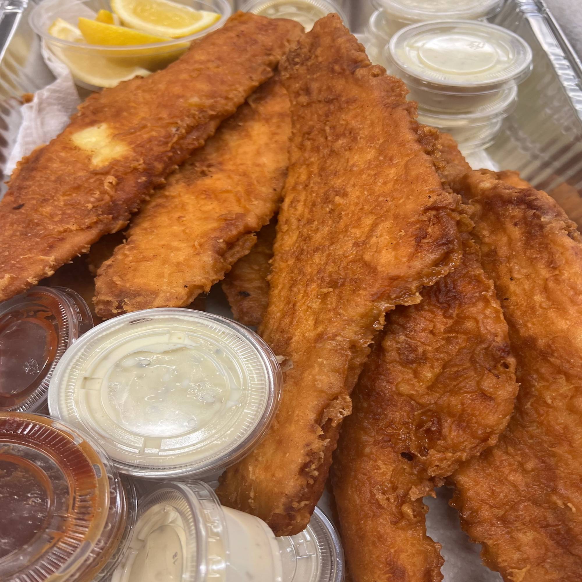 A tray of fish sticks and condiments