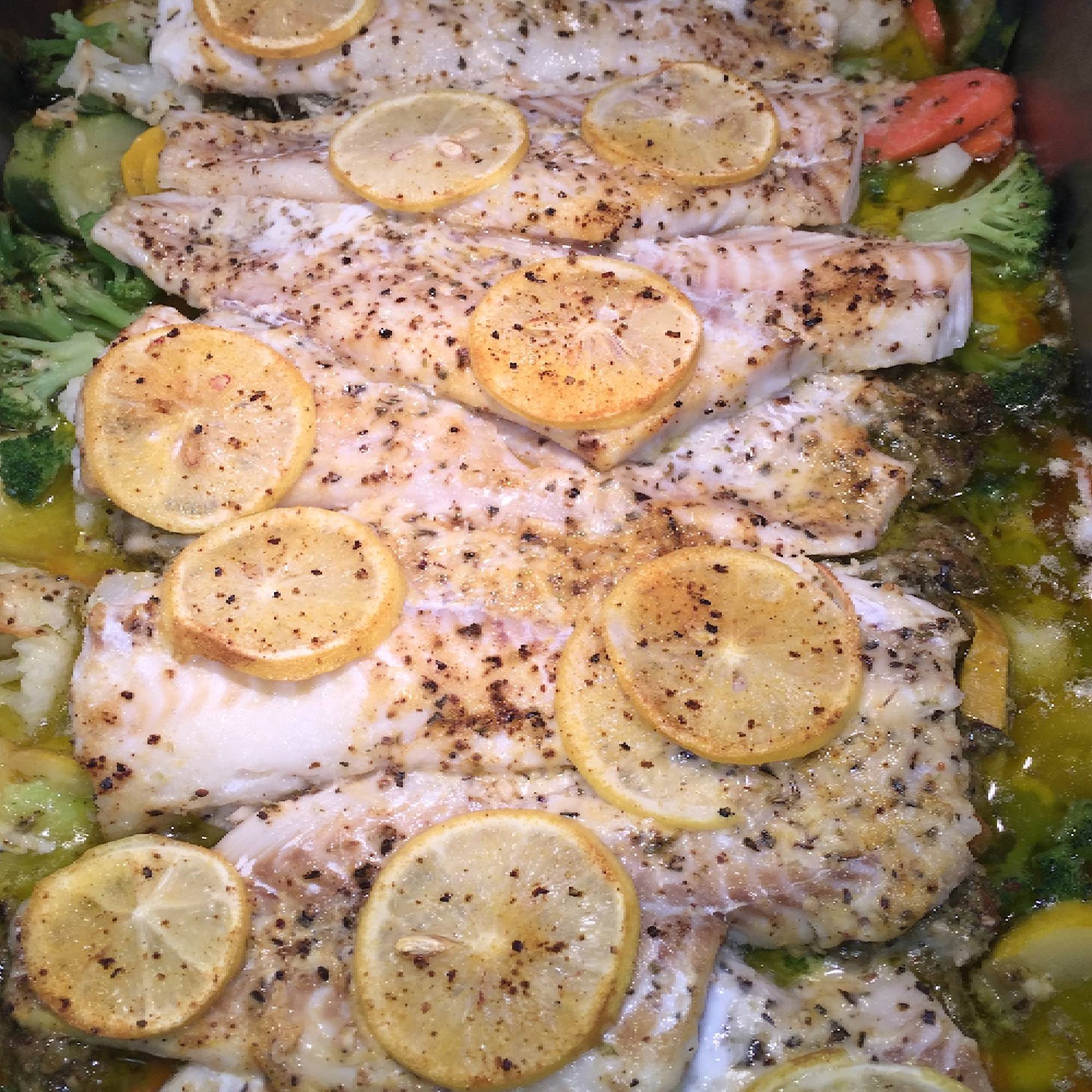 A close up of some fish with lemon slices