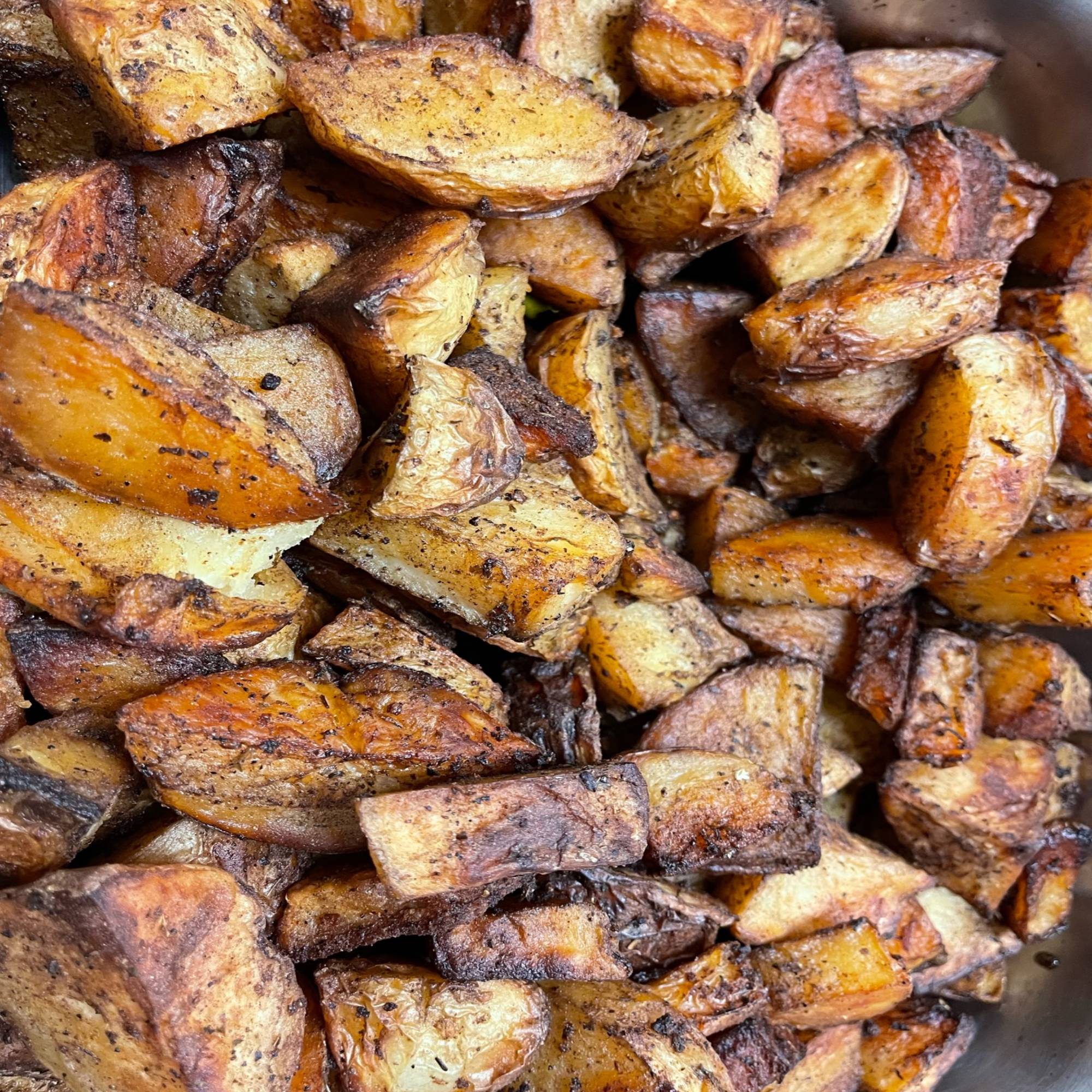A close up of some potatoes in the pan