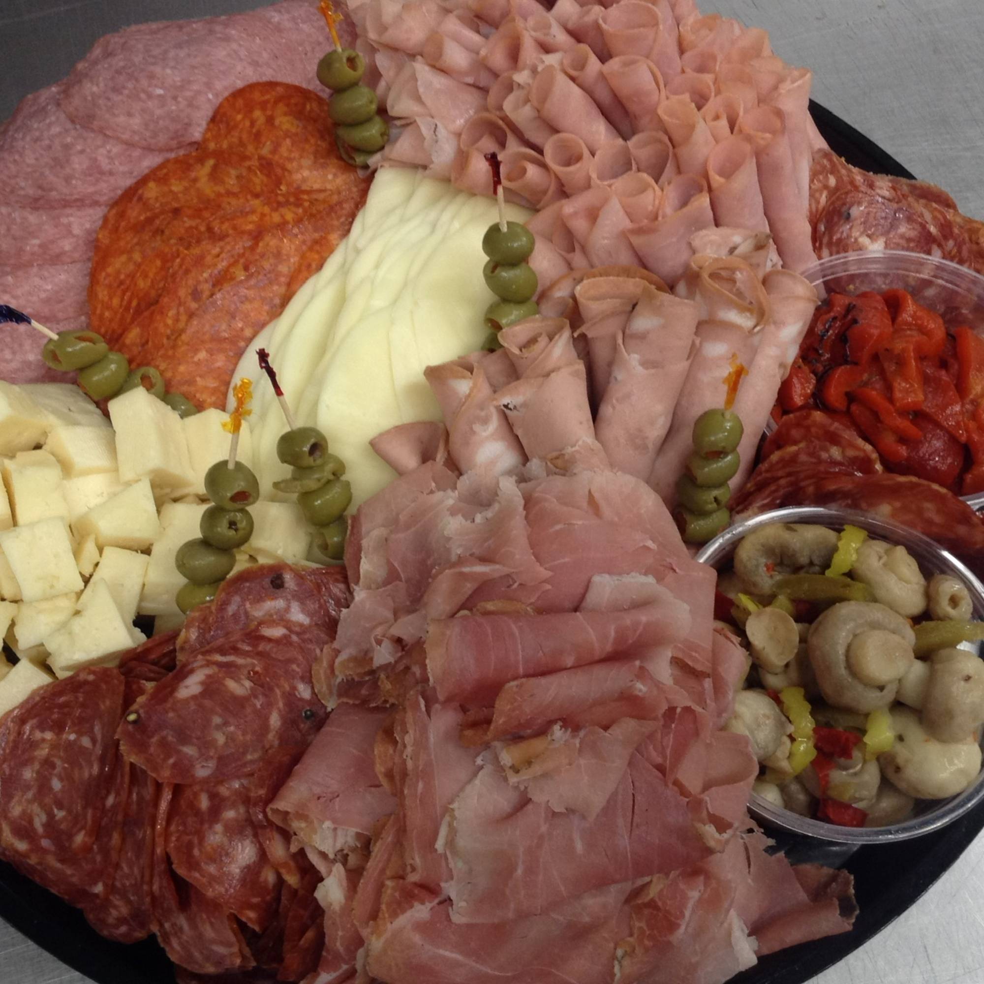 A plate of meat and cheese on the table.