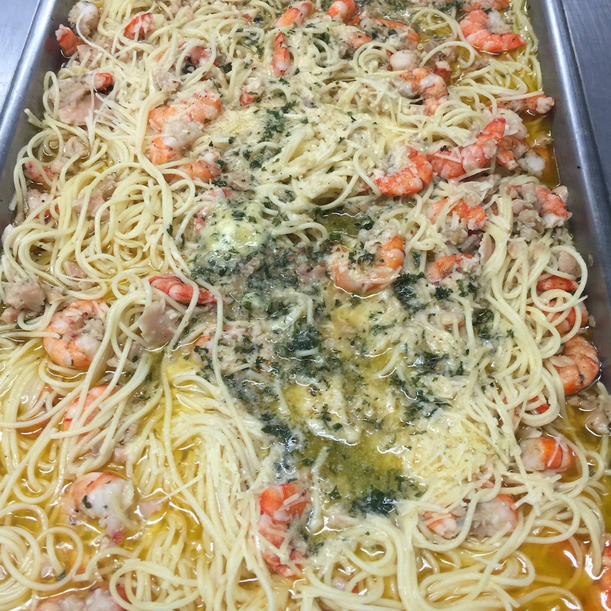 A pan of pasta with shrimp and cheese.