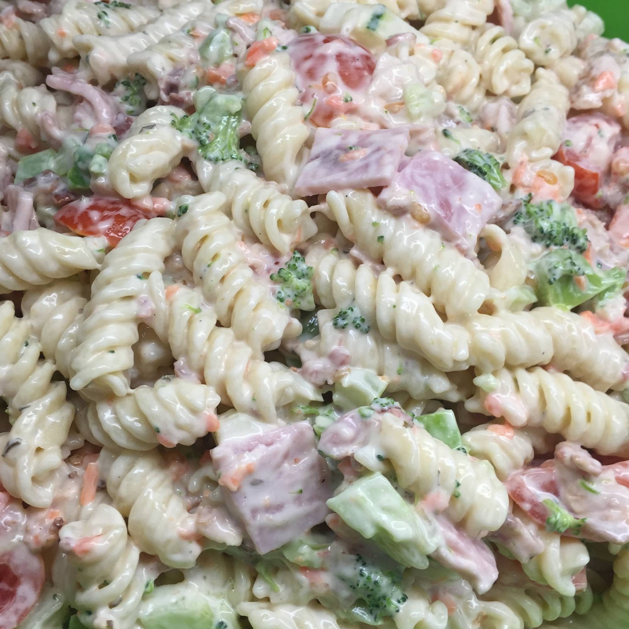 A close up of pasta salad with broccoli and ham