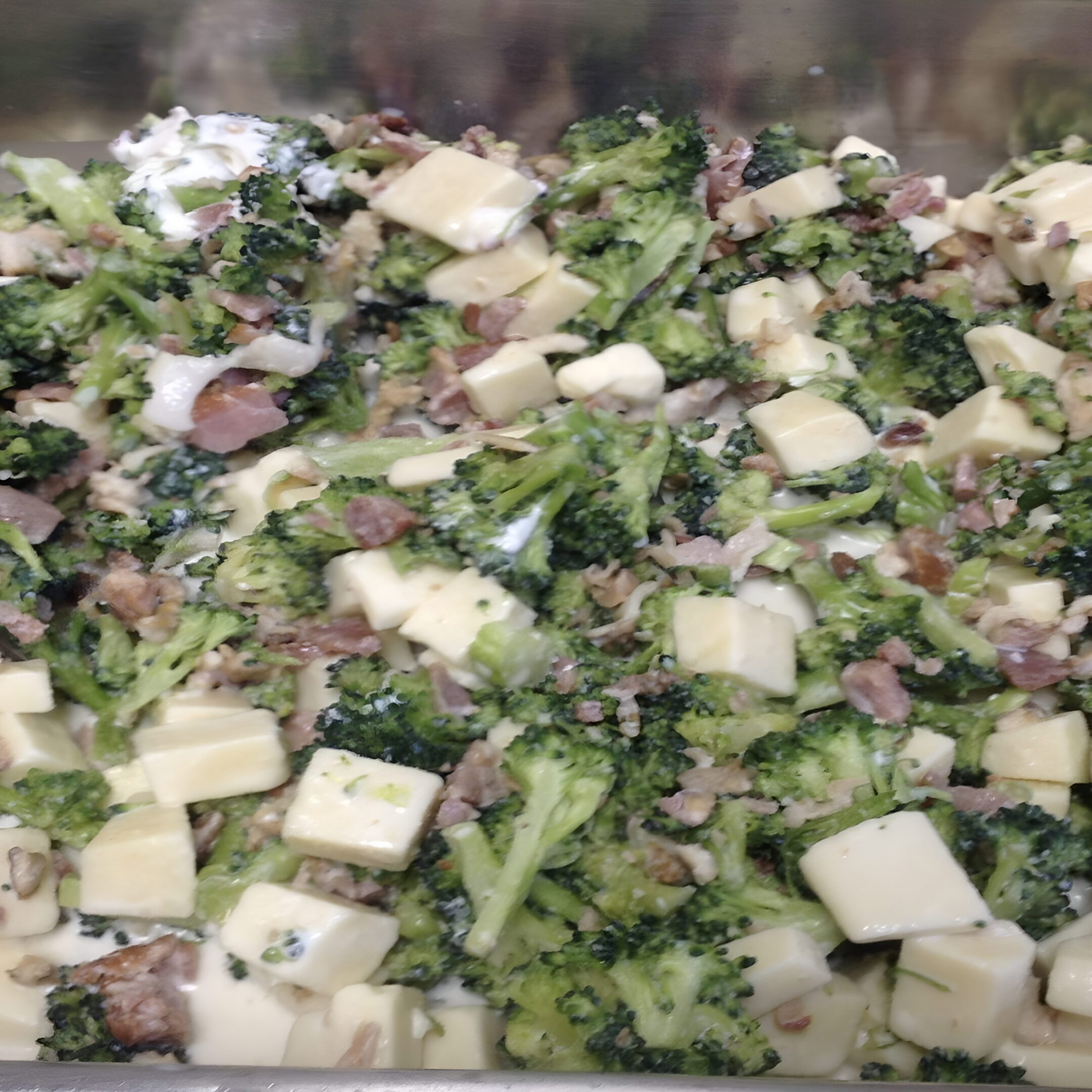 A close up of broccoli and cheese on top of a pan.