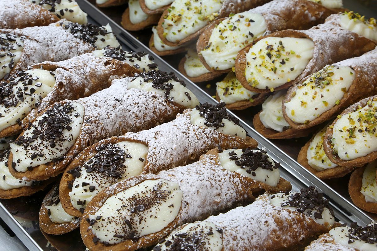 A tray of pastries with powdered sugar on top.