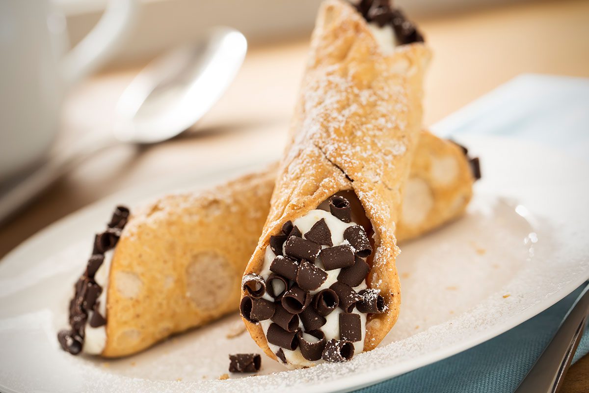 A plate with two chocolate filled crepes on it.