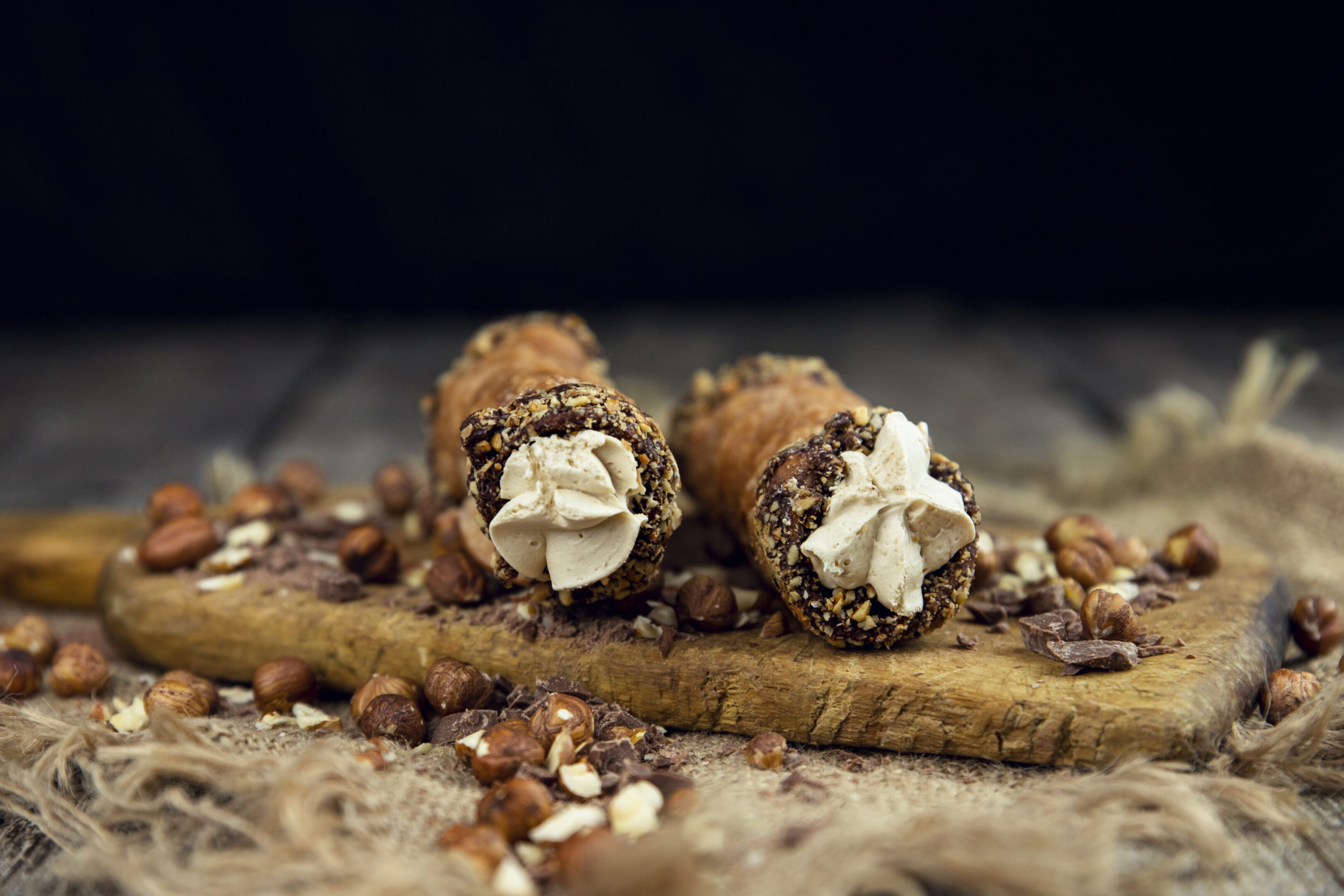 A couple of cones filled with nuts on top of a wooden board.